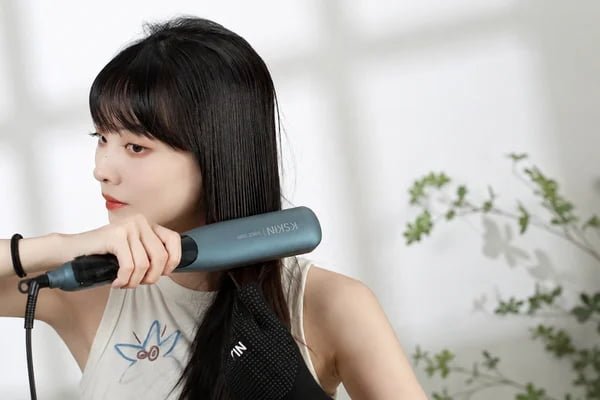 Woman using the KD880 steam hair straightening brush