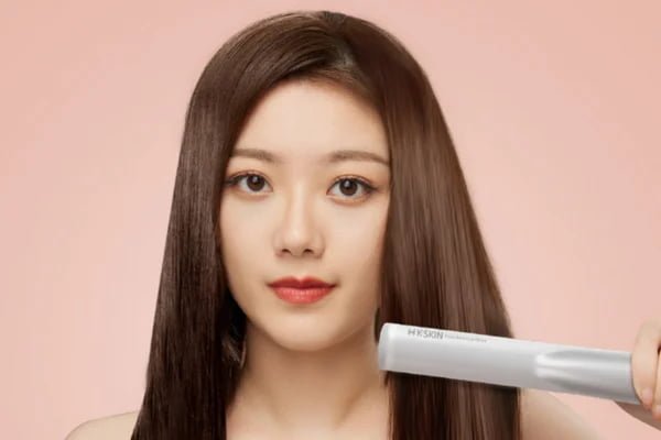 Woman using the KD881 cordless ultrasonic hair care device on long hair