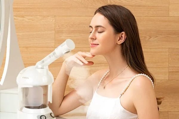 Woman using the KD2328 facial steamer during a skincare routine