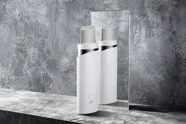 KD8023 ultrasonic skin scrubber displayed with mirror reflection on a gray stone background