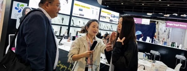 K SKIN Trade Show Buyer Discussion K SKIN team discussing beauty device products with international buyers at a trade show